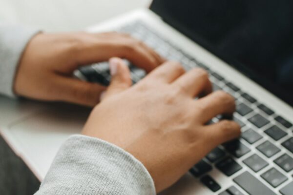 Hands typing on a laptop keyboard - digital accessibility and keyboard navigation