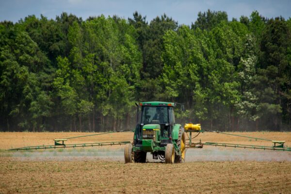 Tractor with a field sprayer applying plant protection products